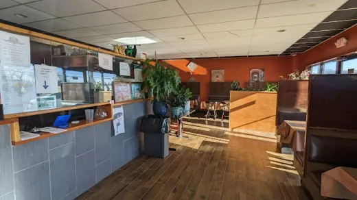 The front counter at Pada Thai, decorated with live plants and warm wood tones